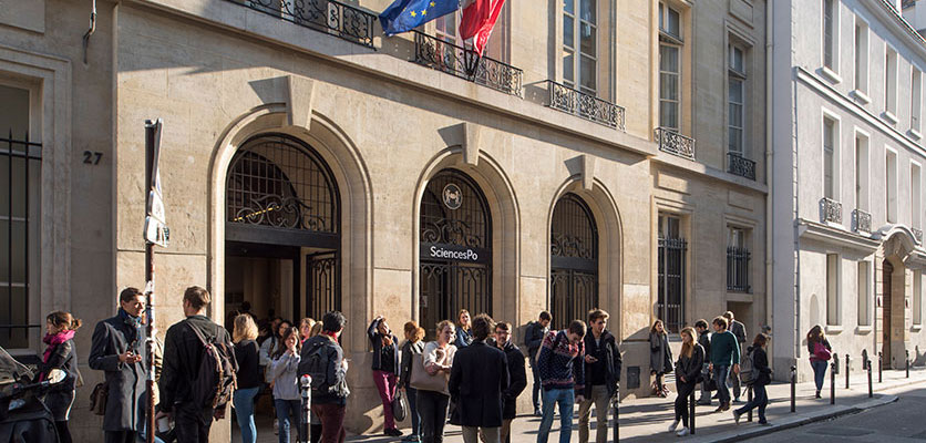 Image of students standing on the street outside a building on the Sciences Po campus.